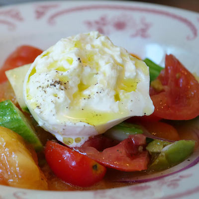 Heirloom tomatoes, with olives, cucumbers, basil, and onions - topped with burrata