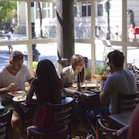 A woman laughing while enjoying brunch at Little Owl